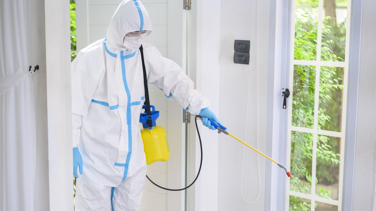 Técnico com EPI realizando sanitização profissional
